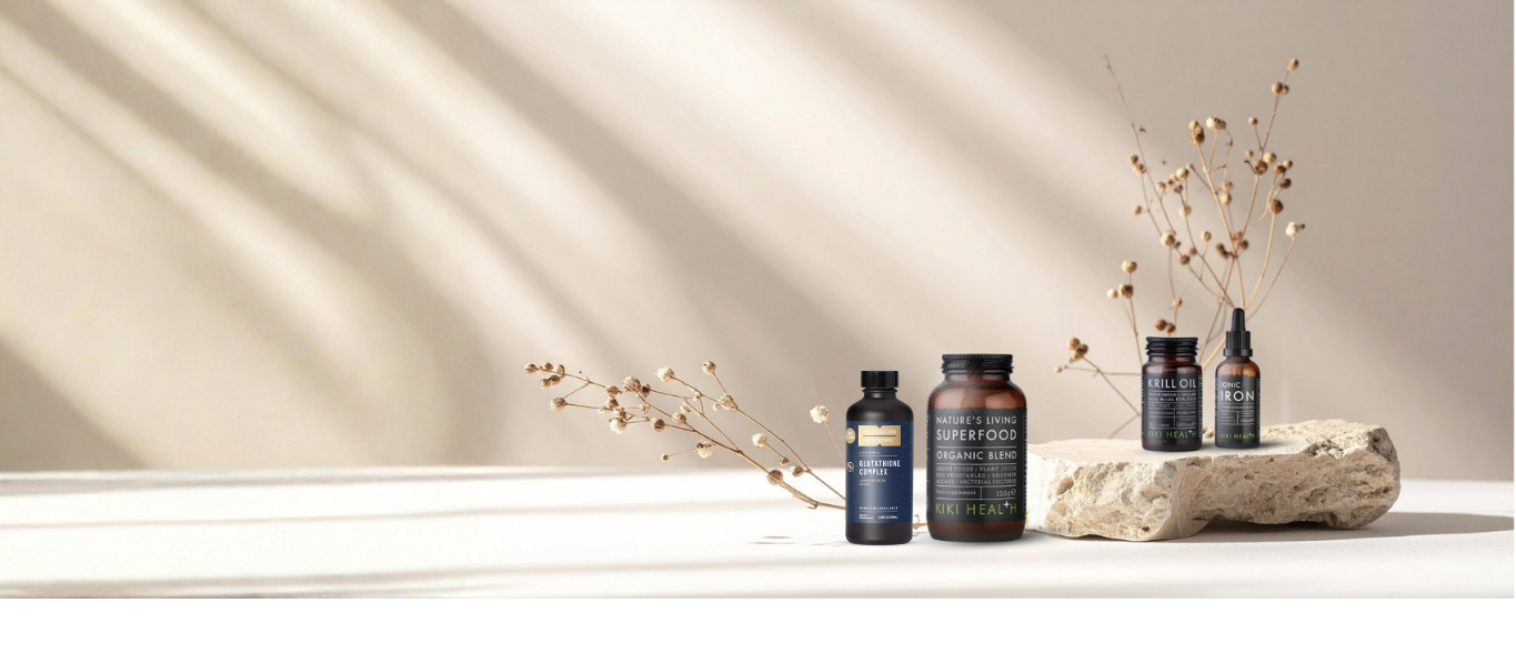 Four supplement bottles on a light surface with a decorative stone and branches in the background